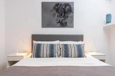 a bedroom with a bed with two lamps on it at Easy Living City Apartment in Chania Town