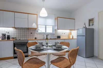 a kitchen with a table and chairs and a refrigerator at Easy Living City Apartment in Chania Town