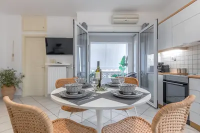 a dining room with a white table and chairs at Easy Living City Apartment in Chania Town