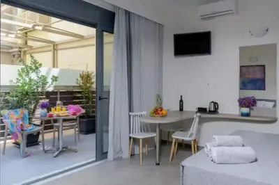 a living room with a bed and a table with chairs at Ginger Chania City Center Apartment in Chania Town