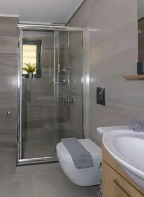 a bathroom with a shower and a toilet and a sink at Ginger Chania City Center Apartment in Chania Town
