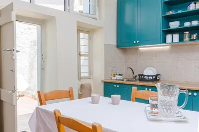 a kitchen with a white table and blue cabinets at Argiro's House - Chania Old Town in Chania Town