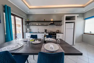 a dining room with a table and a kitchen at Luxury Sea View Apartment in Kolimvari in Kolymvari