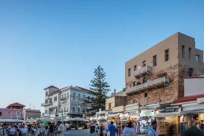 a group of people walking around a market with buildings at La Torre Residenza Imperiale in Chania Town