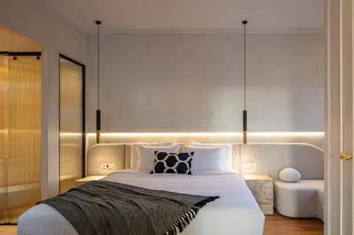 a bedroom with a large white bed and a chair at La Torre Residenza Imperiale in Chania Town