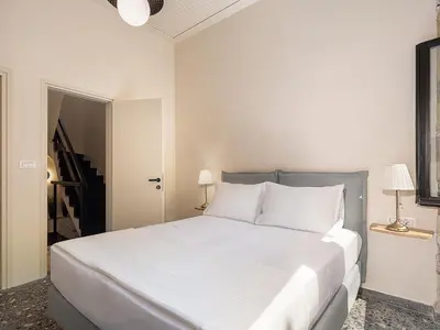 a white bedroom with a large bed with white pillows at Faedra Residence in Chania Town