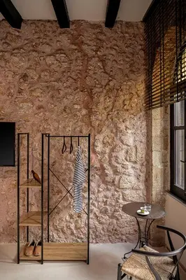 a room with a stone wall with a table and chairs at Faedra Residence in Chania Town