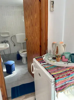 a bathroom with a sink and a toilet and a counter at BONATSA ROOMS in Palaiochóra
