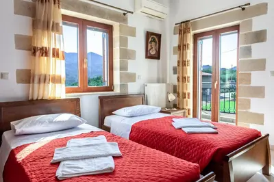 two beds in a room with two windows at Ktima Edem in Ramní