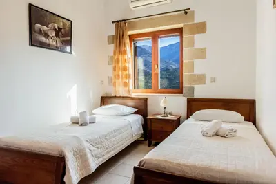 two beds in a room with a window at Ktima Edem in Ramní