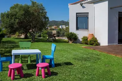 four chairs and a table and two stools in a yard at Villa Pasiphae in Stalos
