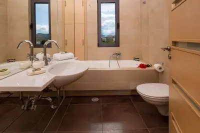 a bathroom with two sinks and a tub and a toilet at Villa Pasiphae in Stalos