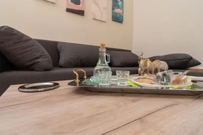 a tray with a plate of food and a bottle on a table at Gemma Apartments in Palaiochóra