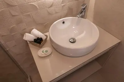 a white sink sitting on a counter in a bathroom at Gemma Apartments in Palaiochóra