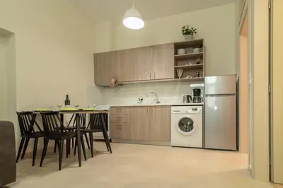 a kitchen with a table and a refrigerator and a dishwasher at Gemma Apartments in Palaiochóra