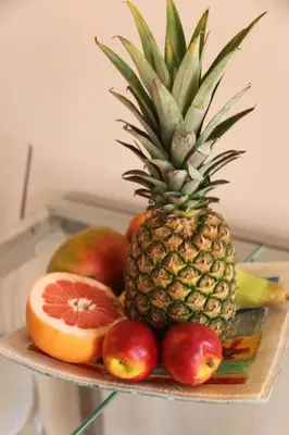a tray with a pineapple and other fruits on it at Kabanas 3 cosy suite in Chania Town