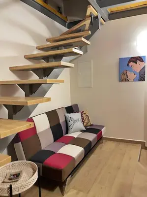 a living room with a couch and a spiral staircase at Kabanas 3 cosy suite in Chania Town
