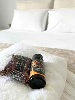 a bottle of alcohol sitting on top of a bed at wave rooms sea view in Maleme