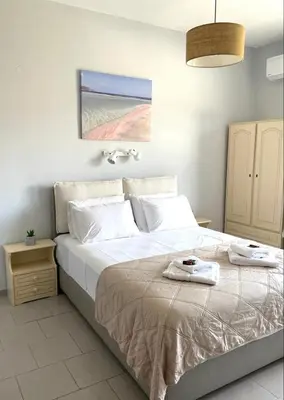 a bed with two towels on it in a bedroom at wave rooms sea view in Maleme