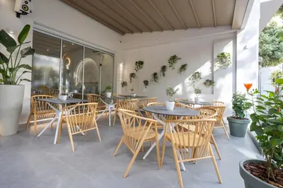a patio with tables and chairs and potted plants at Epavli Grace Hotel in Chania Town