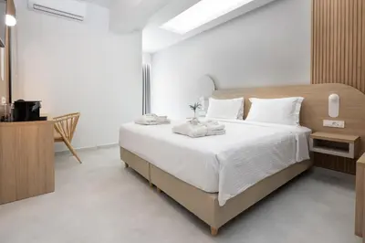a bedroom with a large bed with white sheets at Epavli Grace Hotel in Chania Town