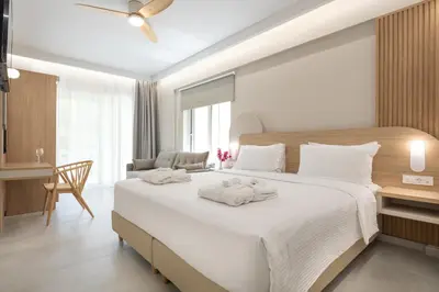 a bedroom with a large white bed with towels on it at Epavli Grace Hotel in Chania Town