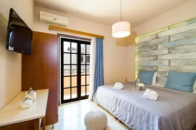 a bedroom with a bed and a flat screen tv at Evangelos Apartments in Plataniás