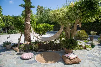 a hammock in a garden with trees and plants at Evangelos Apartments in Plataniás