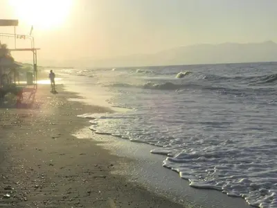a person riding a surfboard on the beach at Evangelos Apartments in Plataniás