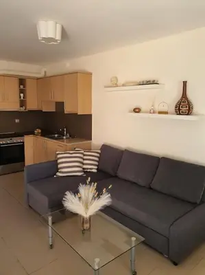 a living room with a couch and a glass table at Korais apartment, Chania Crete in Kounoupidhianá