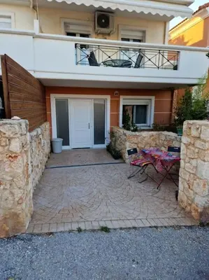 a patio in front of a house with a balcony at Korais apartment, Chania Crete in Kounoupidhianá