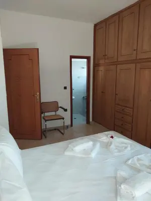a bedroom with a large white bed and a chair at Passatempo Casa - 3 bedroom apartment close to the swimming pool in Gerani Chanion