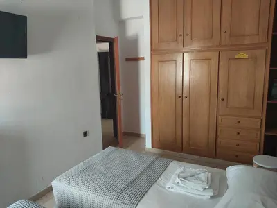 a bedroom with a bed and a wooden cabinet at Passatempo Casa - 3 bedroom apartment close to the swimming pool in Gerani Chanion
