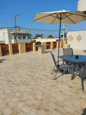 a patio with a table and an umbrella at Passatempo Casa - 3 bedroom apartment close to the swimming pool in Gerani Chanion