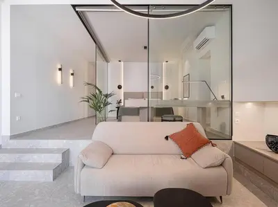 a living room with a couch and glass walls at Ares Luxurious Residence in Kolymvari