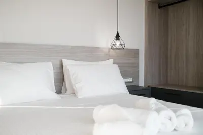 a bedroom with a bed with white sheets and pillows at Sky-High Central Penthouse w. Stunning Views - 01 in Chania Town