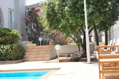 a patio with a swimming pool and some trees at Chrysiida Suites in Tersanas
