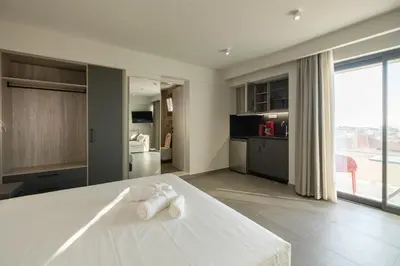 a kitchen and living room with a white table at Sky-High Central Penthouse w. Stunning Views - 03 in Chania Town