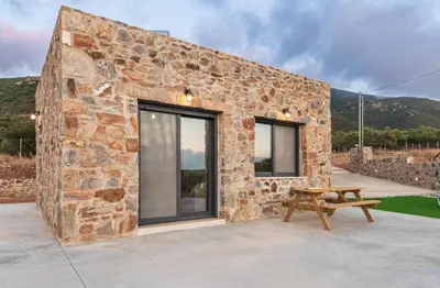 a stone house with a picnic table in front of it at The Rock *Peaceful Retreat House in Kámbos