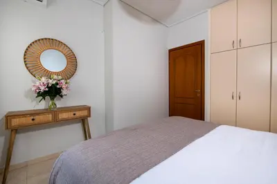 a bedroom with a bed and a mirror and a table at Inner City Retreat Apartment in Chania Town