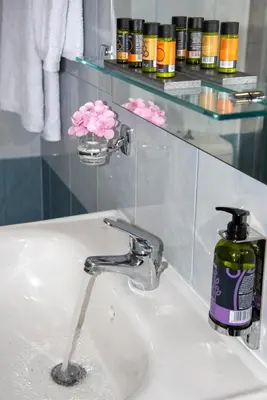 a bathroom sink with a faucet and a bottle of soap at Inner City Retreat Apartment in Chania Town