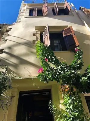 a building with flowers on the side of it at Traditional 3 Story Townhouse ,Batta Hanem in Chania Town