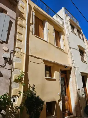 a yellow building with a balcony on top of it at Traditional 3 Story Townhouse ,Batta Hanem in Chania Town