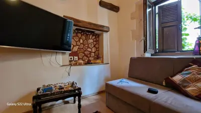 a living room with a couch and a flat screen tv at Traditional 3 Story Townhouse ,Batta Hanem in Chania Town