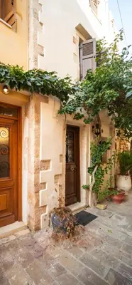 a building with a tree on the side of it at Traditional 3 Story Townhouse ,Batta Hanem in Chania Town