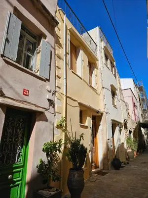 a building with a green door on a street at Traditional 3 Story Townhouse ,Batta Hanem in Chania Town