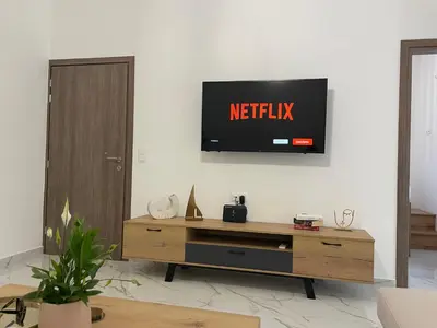 a living room with a television on a wall at SK Luxury Residence in Chania Town