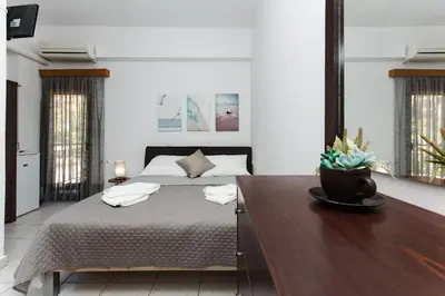 a bedroom with a bed and a wooden table at En Plo Beachfront Rooms in Falasarna