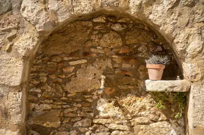 a stone wall with a potted plant in a window at Kantoni traditional house in Maláthiros