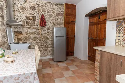 a kitchen with a table and a refrigerator at Kantoni traditional house in Maláthiros